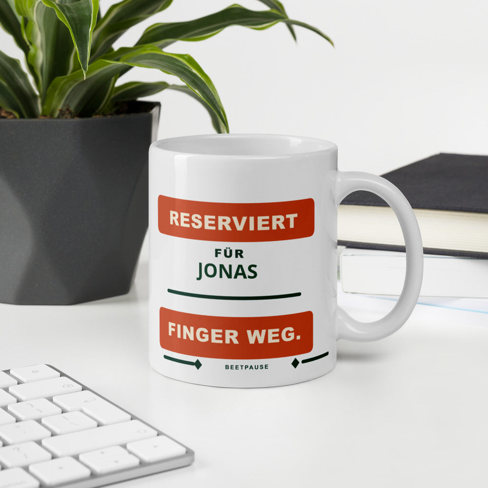 Personalisierte Gartentasse neben Tastatur und Zimmerpflanze